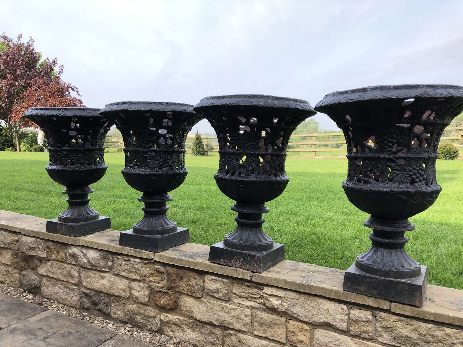 Set of four cast iron urns pierced and foliate design