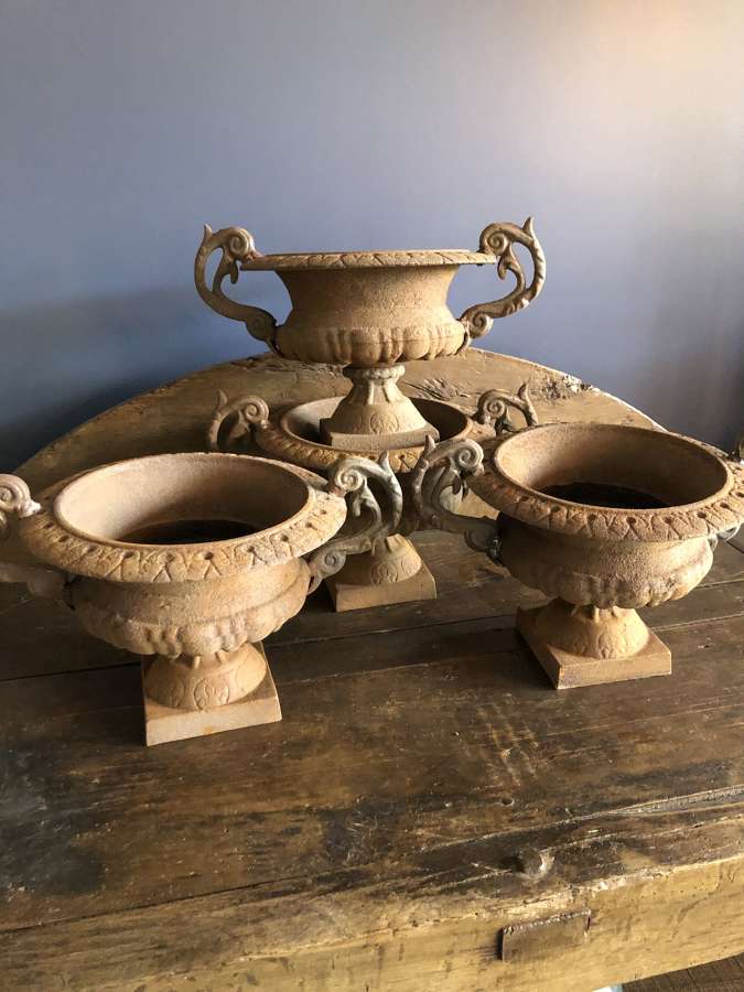 Set of four cast iron urns with handles
