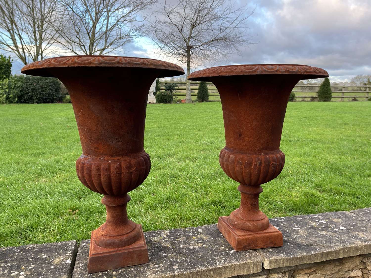 Pair of rusty cast iron urns - cast iron planters