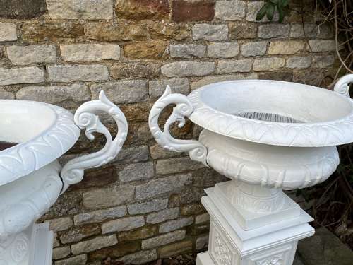 Pair of large cast iron urns & plinths
