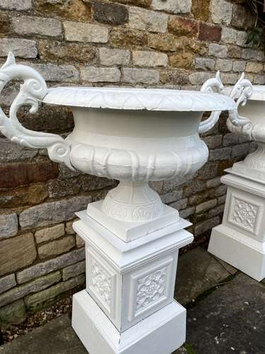 Pair of large cast iron urns & plinths