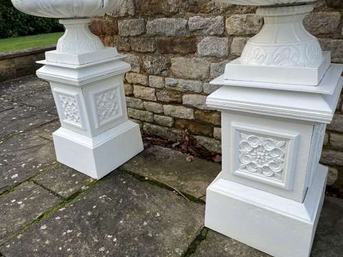 Pair of large cast iron urns & plinths