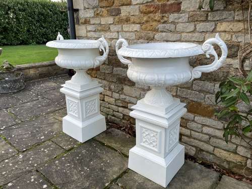 Pair of large cast iron urns & plinths