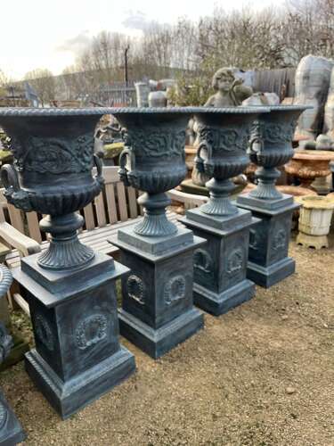 Large pair of cast iron urns and plinths
