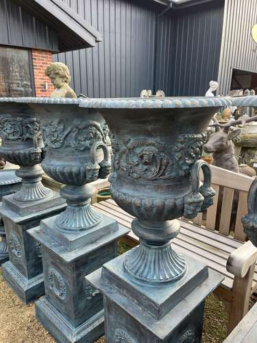 Large pair of cast iron urns and plinths