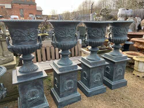 Large pair of cast iron urns and plinths
