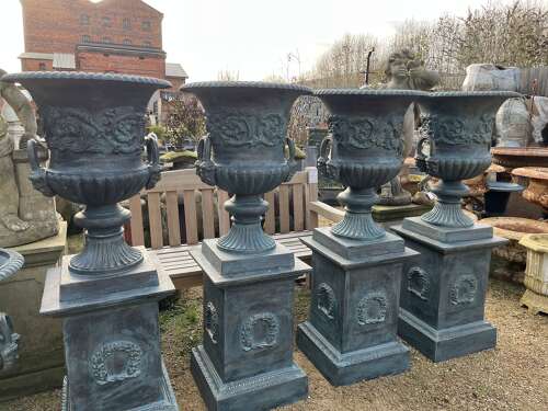 Large pair of cast iron urns and plinths