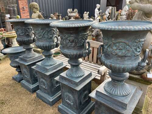 Large pair of cast iron urns and plinths