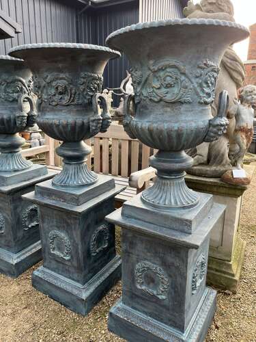 Large pair of cast iron urns and plinths