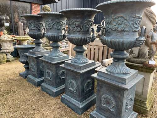 Large pair of cast iron urns and plinths