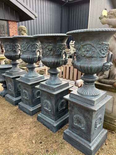 Large pair of cast iron urns and plinths