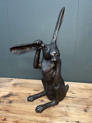 Hare sculpture - bronze hare touching ear.
