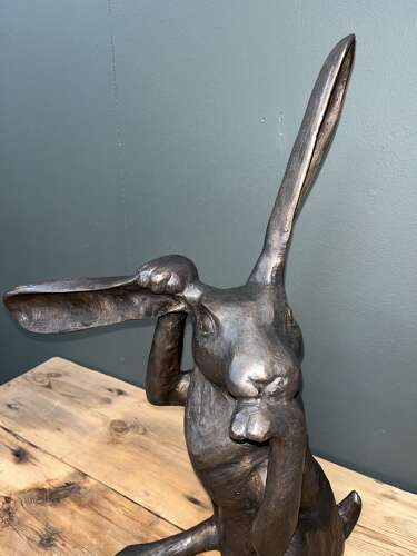 Hare sculpture - bronze hare touching ear.